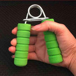 Hand using hand strength training equipment with green foam grips for effective exercise and rehabilitation.