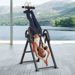 foldable inversion table for strength training with a user performing an inversion in a scenic setting.